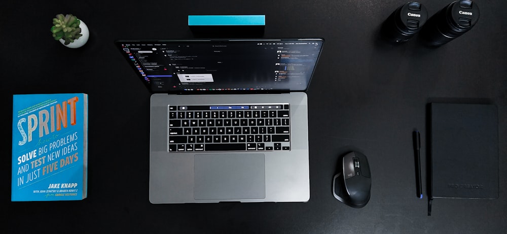 macbook pro beside black and gray cordless mouse