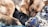 A resting German Shepherd dog cuddles closely with several black puppies on a colorful pile of fabrics, conveying warmth and care.