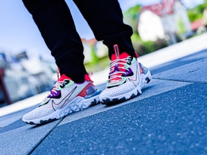 A man wearing lightweight low-top shoes while walking in a vibrant urban setting.