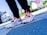 A pair of colorful athletic shoes on a person's feet, with a focus on detailed design and vibrant colors. The background is blurred with an outdoor setting giving a sense of movement or urban style.