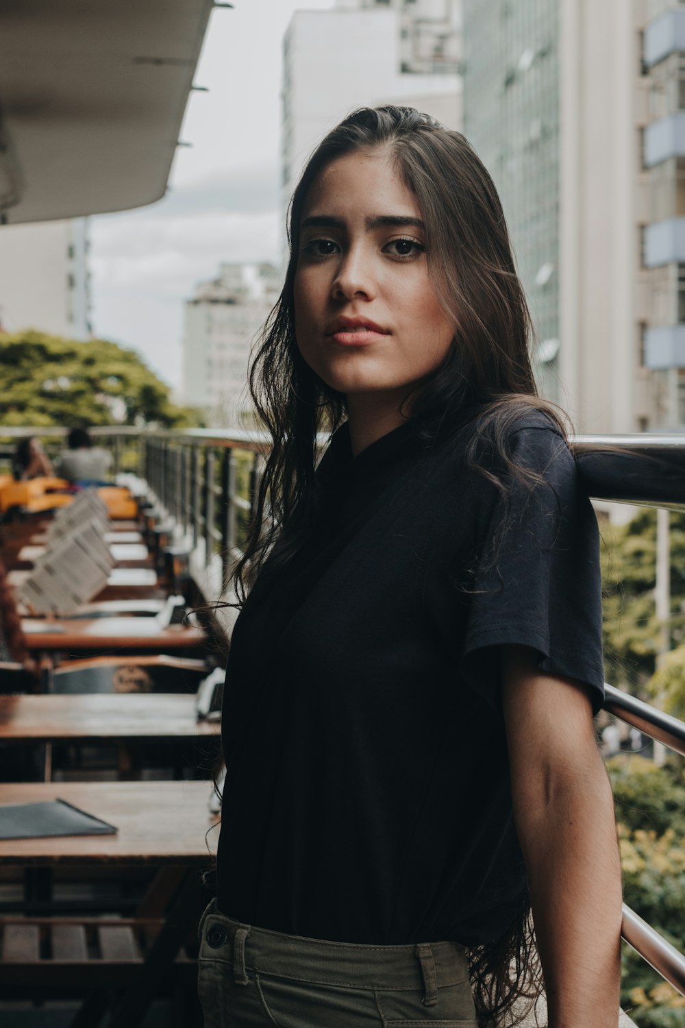 woman in black button up shirt standing near brown wooden table during daytime