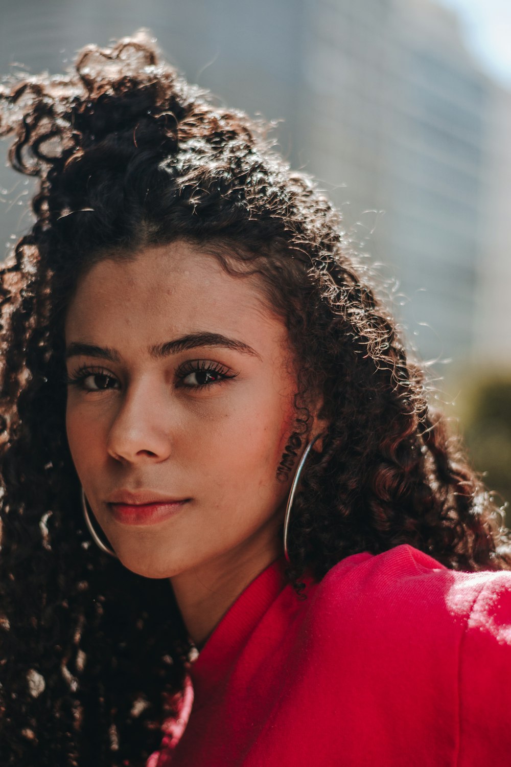 woman in red shirt with curly hair