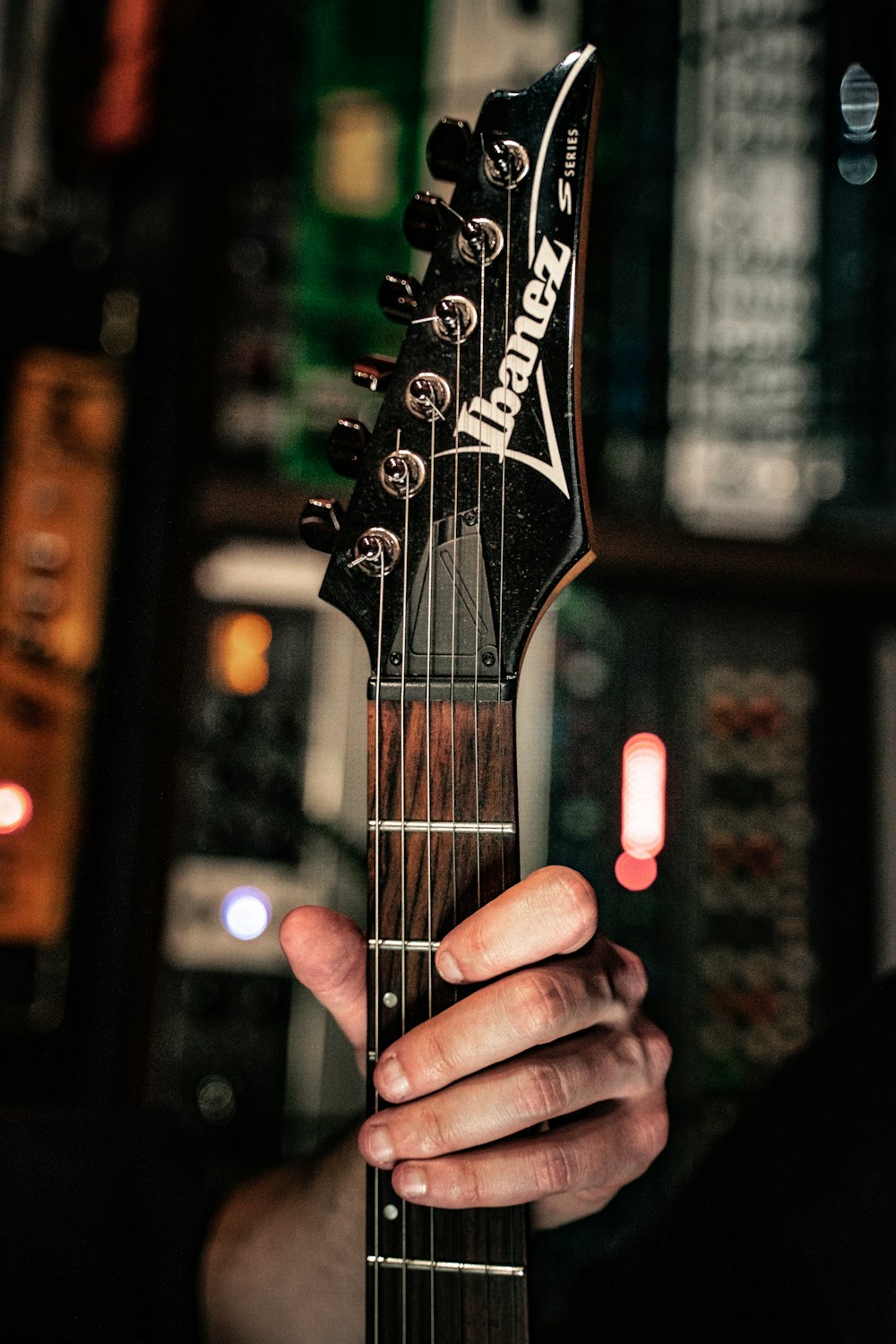 person playing black and white electric guitar