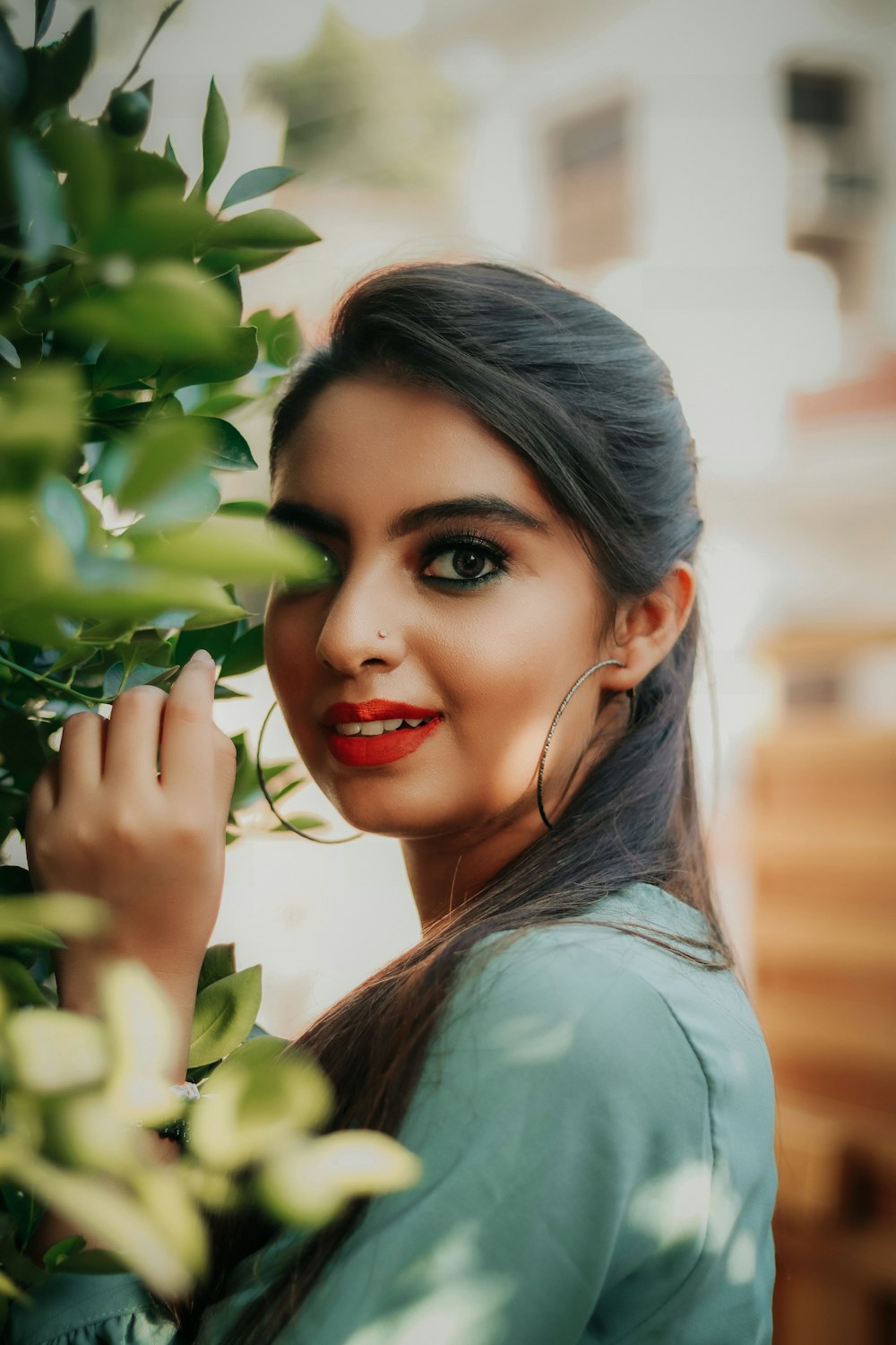 woman in green shirt holding green leaves