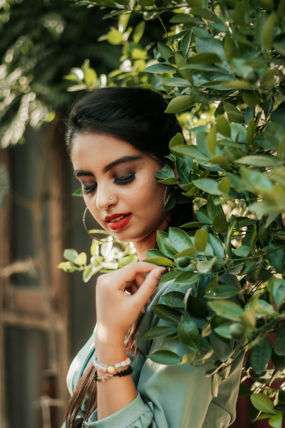 woman in white dress holding green leaves