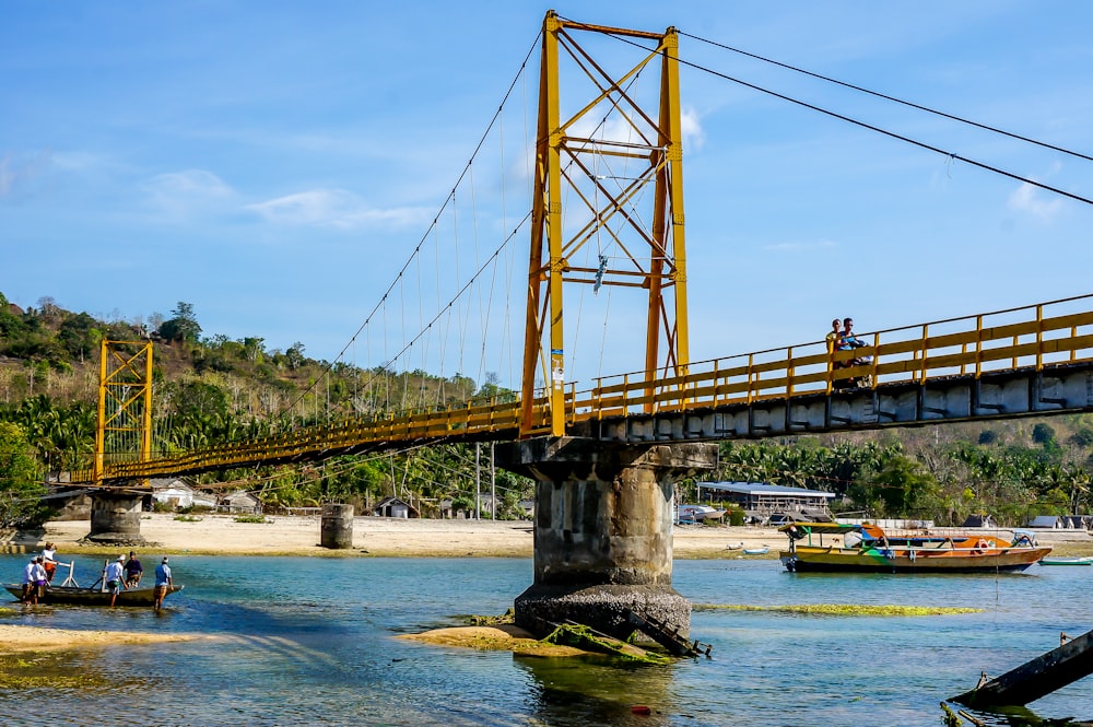 brown bridge over river under blue sky during daytime