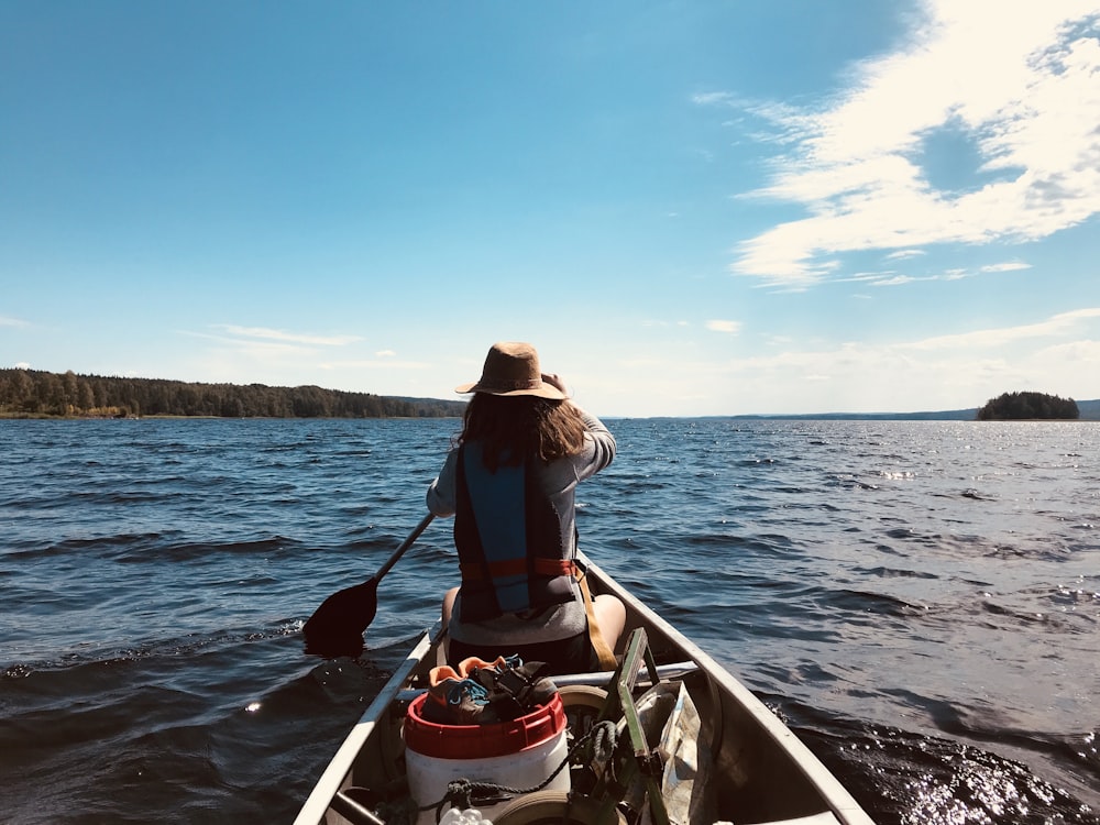 woman in brown sun hat riding on boat during daytime