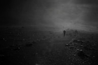 A lone figure walking a narrow path under a stormy sky, embodying isolation and struggle.