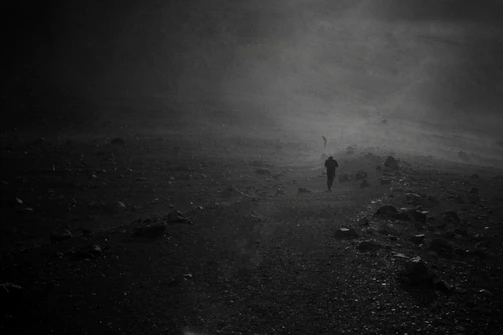 Still from a moody black-and-white short film featuring a lone figure walking through fog.