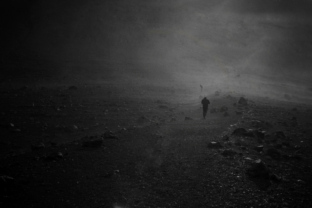 person in black jacket standing on gray sand during daytime