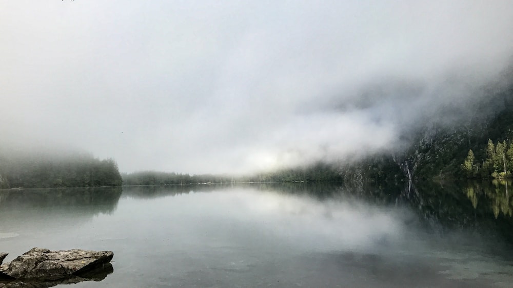 body of water under white clouds during daytime