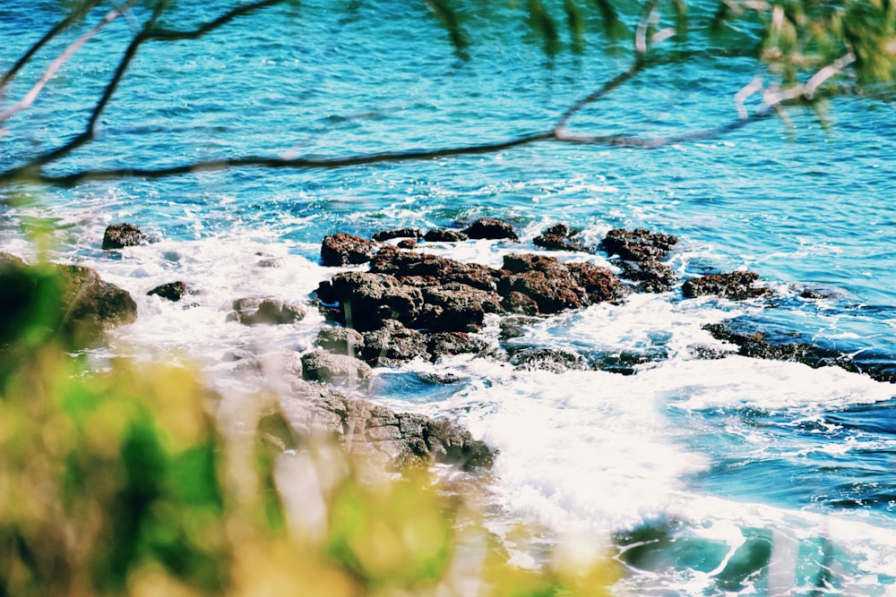 brown rock formation on body of water during daytime