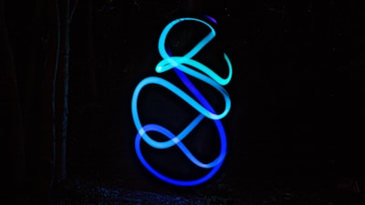 Abstract circuit board glowing in electric blue and neon green on a dark navy background.