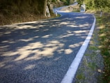 A freshly paved road stretching through a rural landscape, highlighting smooth asphalt and clear markings.