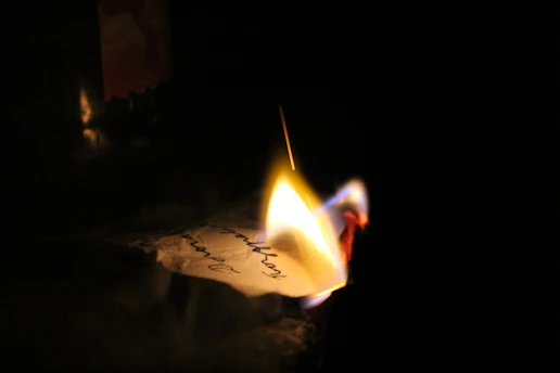 A dimly lit, blurred photo of a handwritten note on aged paper.