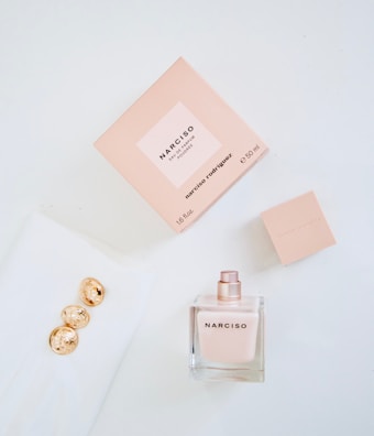 An elegant flat lay featuring Nilza perfume bottles alongside delicate flowers and perfume notes.