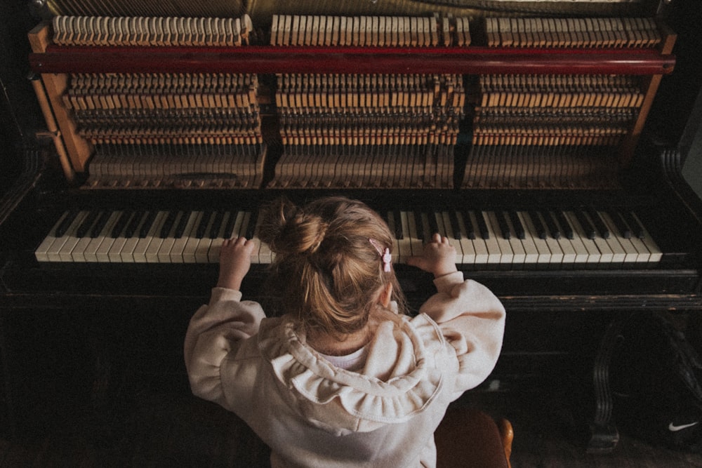 girl in white sweater playing piano