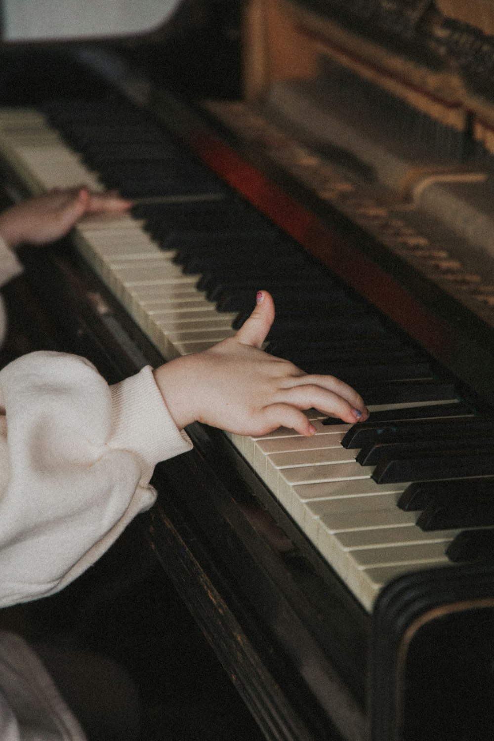 persona in camicia bianca a maniche lunghe che suona il pianoforte