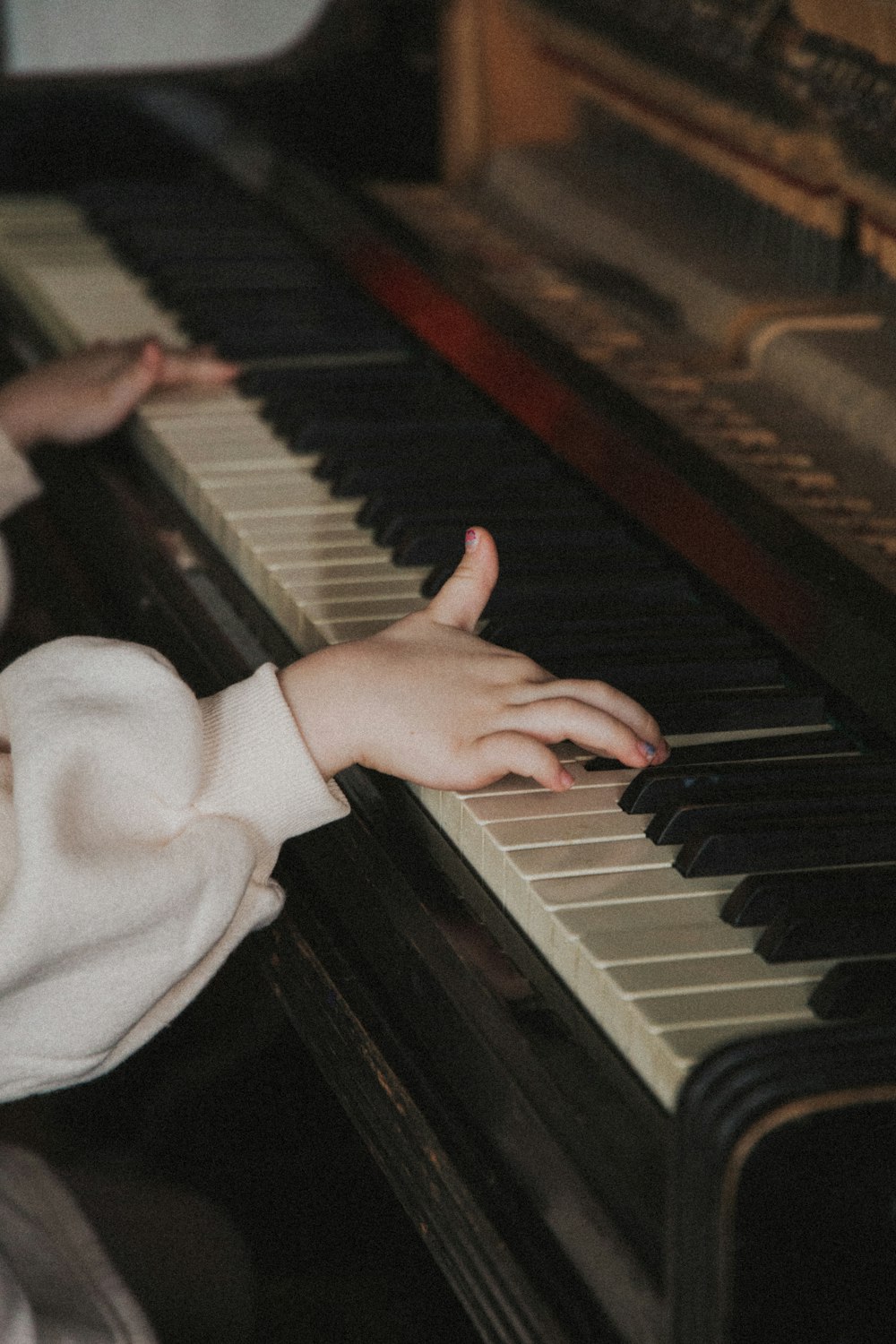 person in white long sleeve shirt playing piano