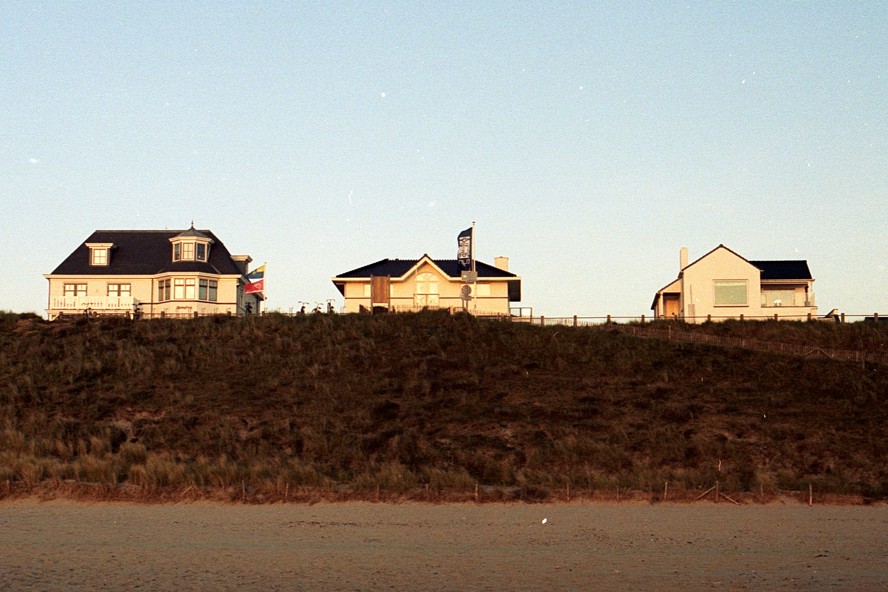 brown and white concrete house near brown grass field during daytime