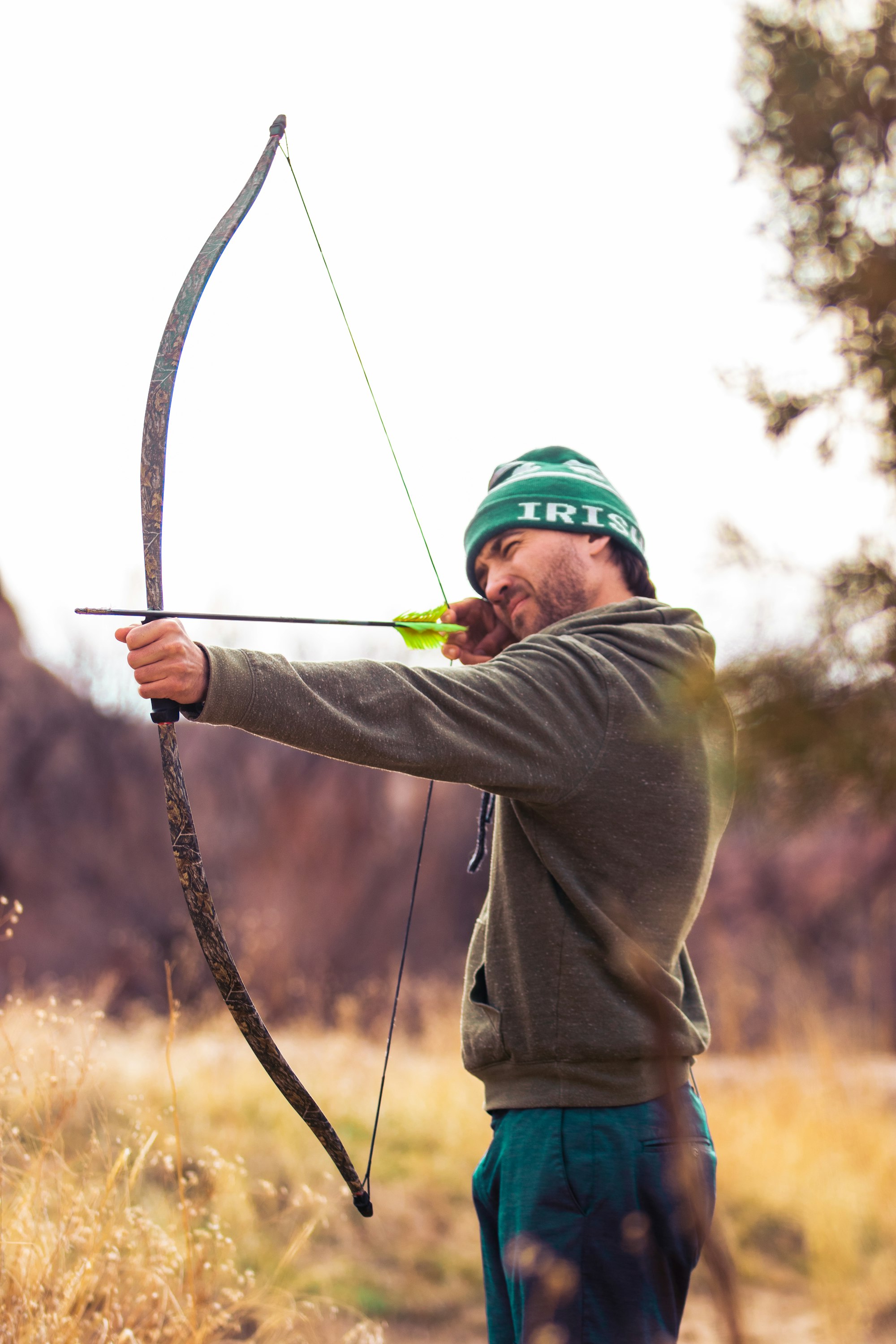 Man hunting in brush with bow and arrow 