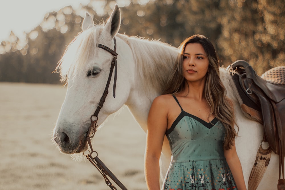 Foto mujer con vestido azul de correa de espagueti de pie junto a un  caballo blanco durante el día – Imagen Caballo gratis en Unsplash