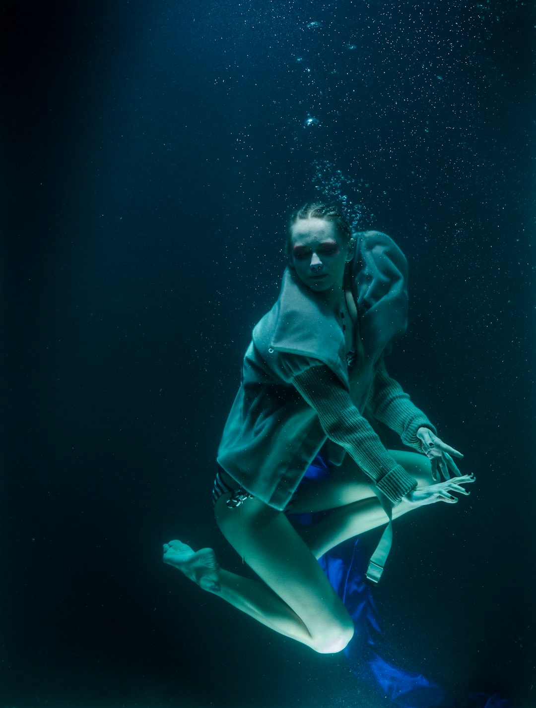 woman in black leather jacket and blue shorts under water