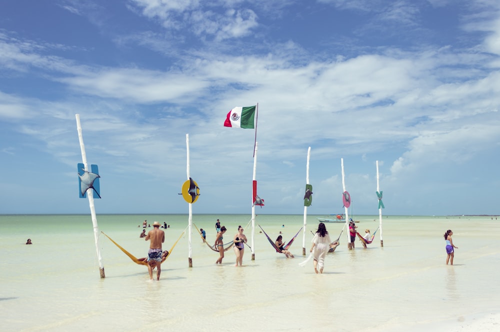 pessoas segurando bandeiras na praia durante o dia