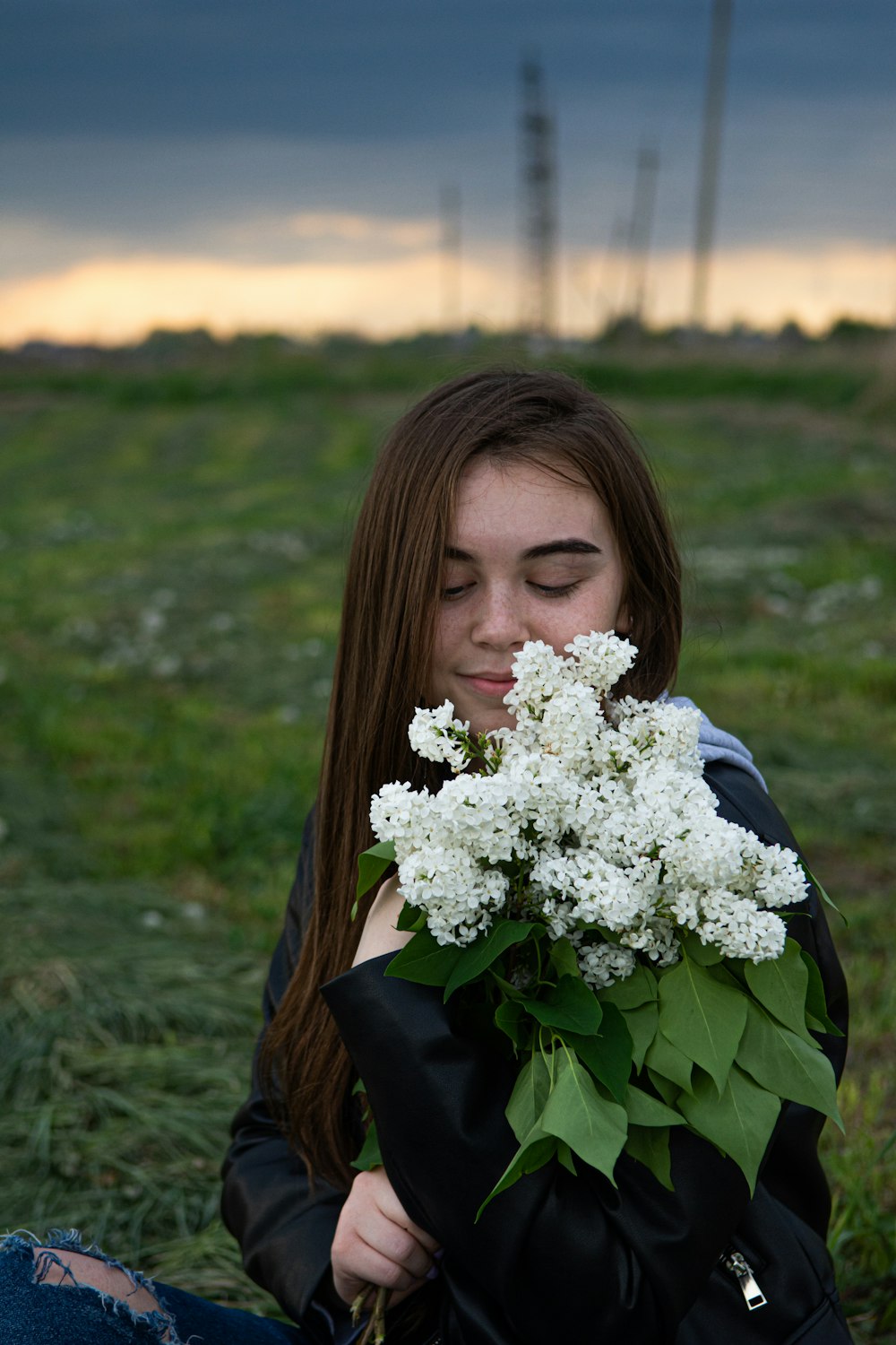 woman in blue long sleeve shirt holding white flowers