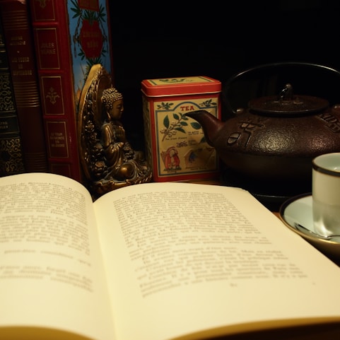 A cozy corner with a stack of ancient Chinese metaphysics books and a teacup steaming gently beside them.