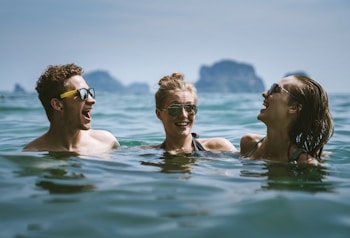 3 women in swimming pool during daytime