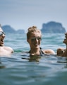 3 women in swimming pool during daytime