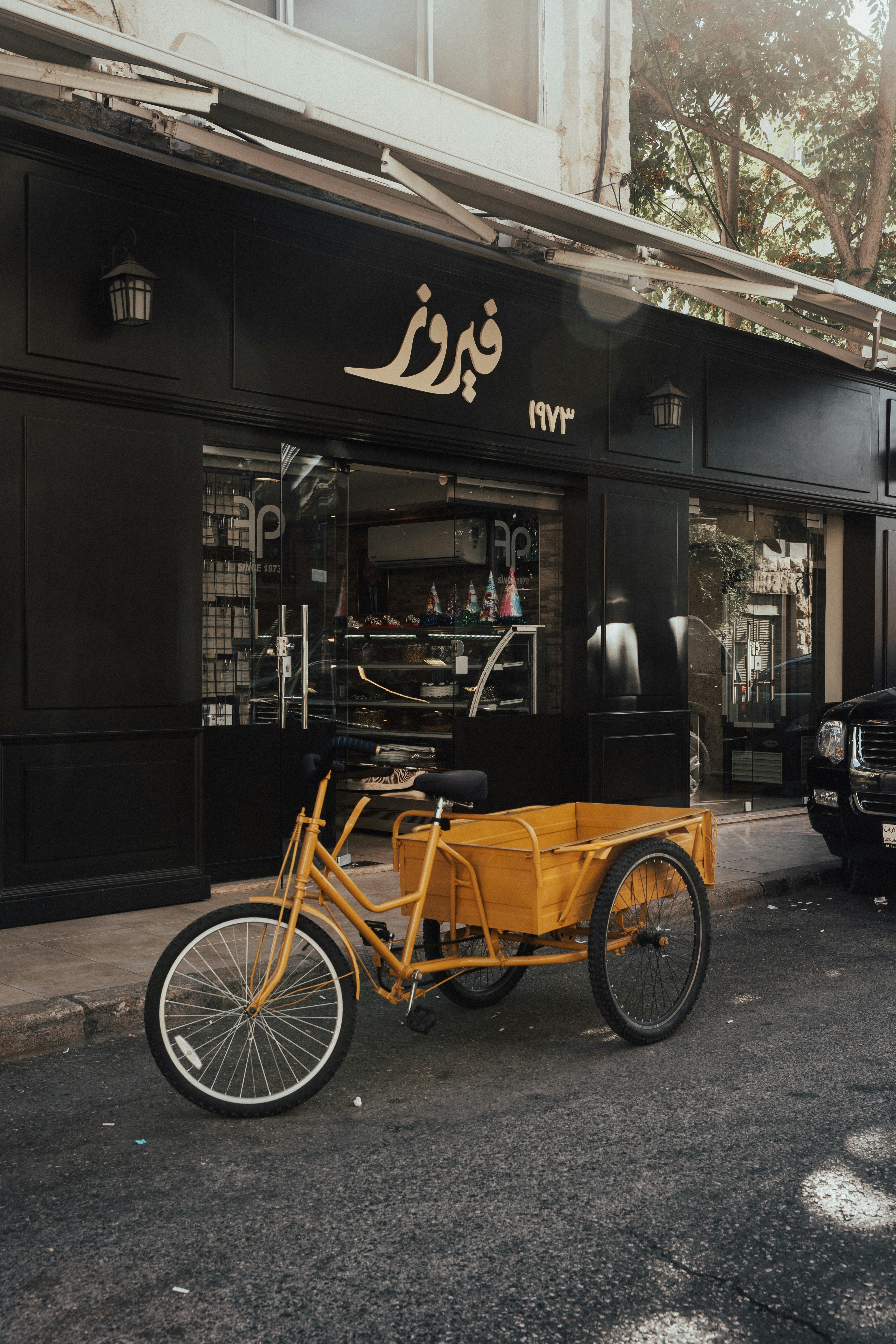 black and brown trike parked beside brown wooden store during daytime