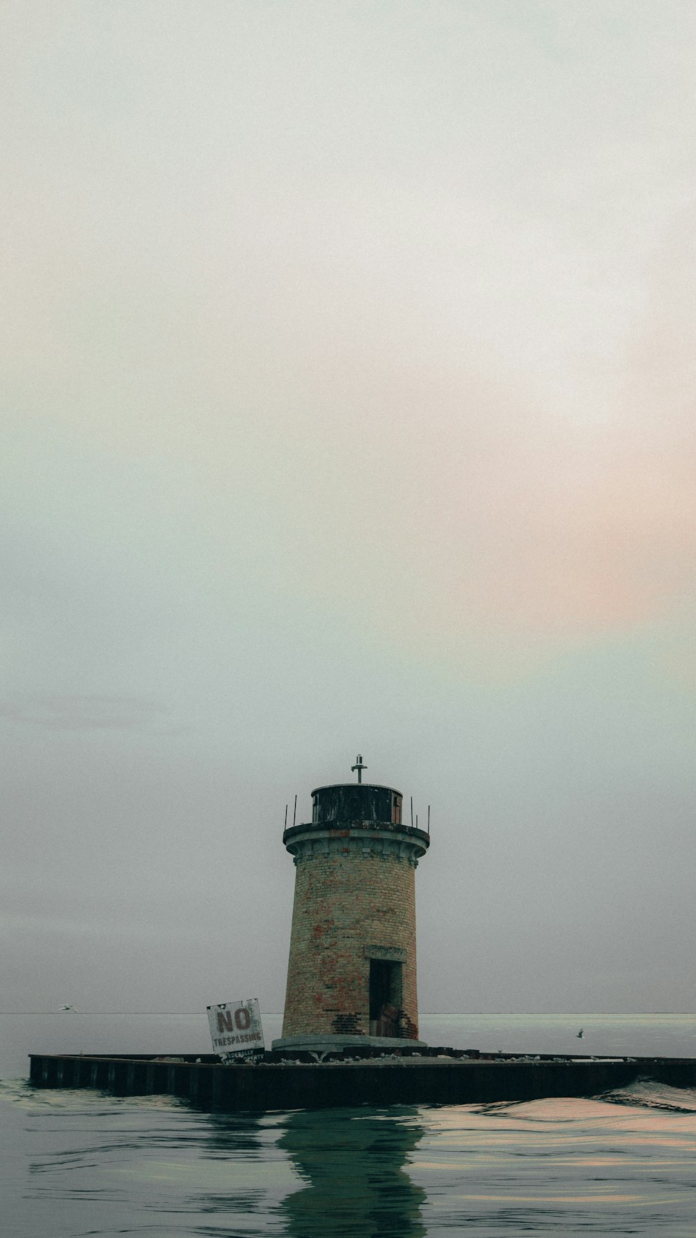 brown and white lighthouse under white clouds