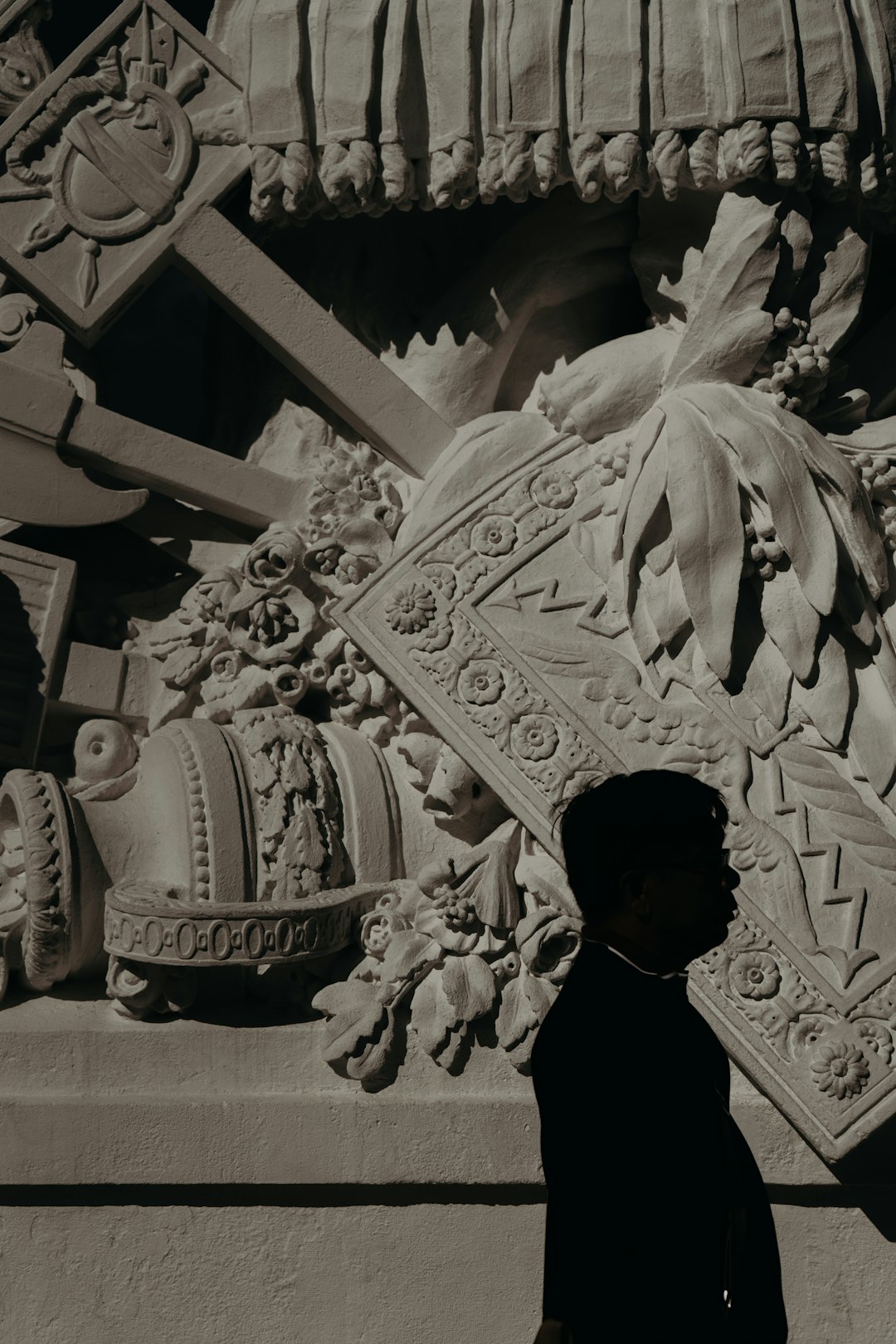 man in black shirt standing in front of gold dragon statue