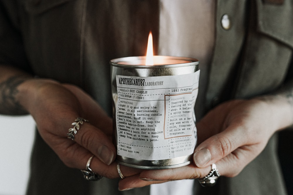 person holding white labeled can