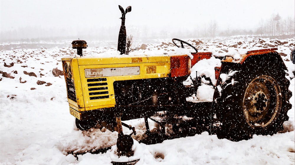 yellow and black tractor on snow covered ground during daytime