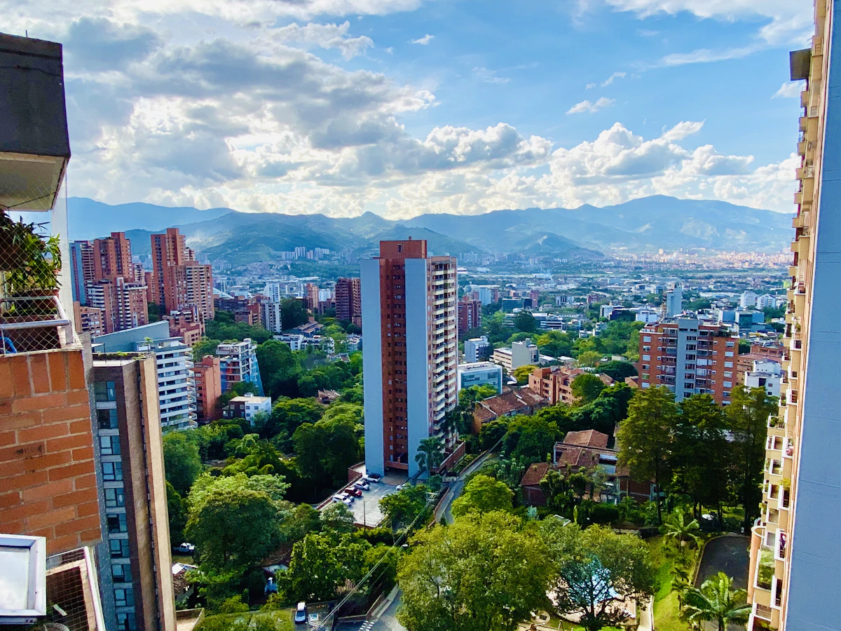 Vista de Medellín desde El Poblado: torres de ladrillo, zonas verdes y las montañas del valle de Aburrá al fondo