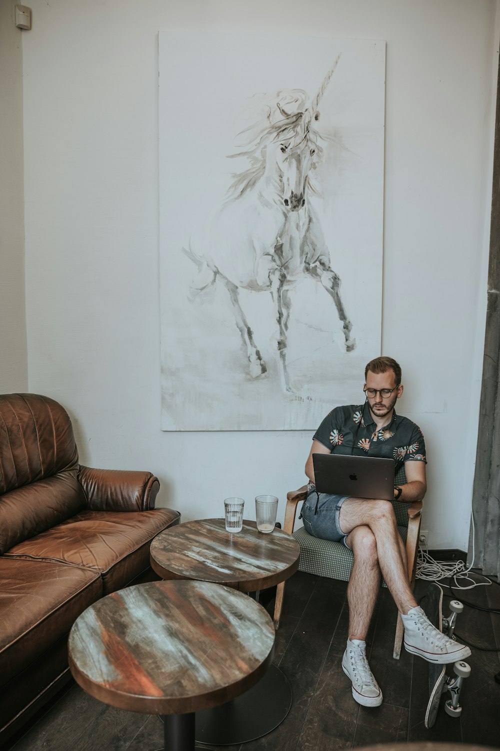 man in black shirt sitting on brown sofa