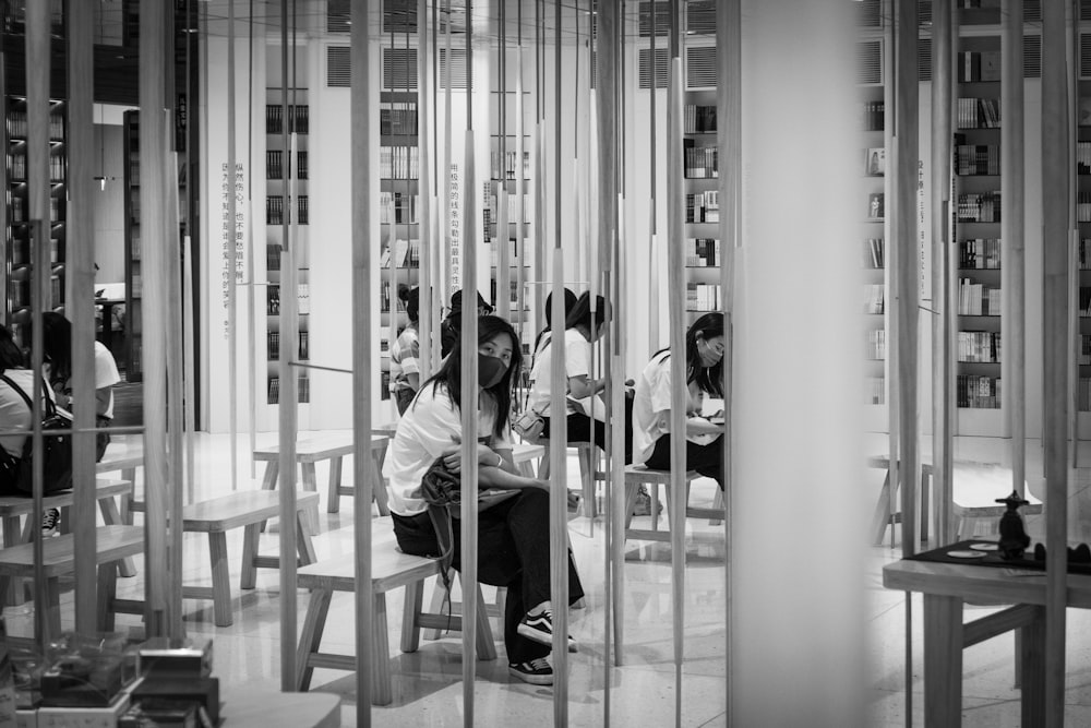 grayscale photo of people walking inside building