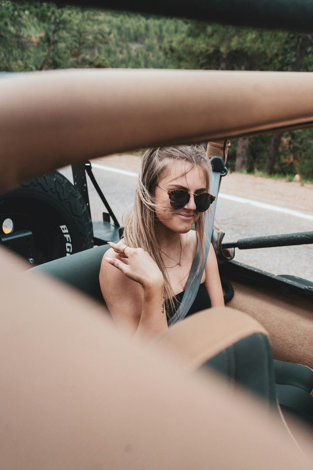 woman in black tank top wearing sunglasses driving car during daytime