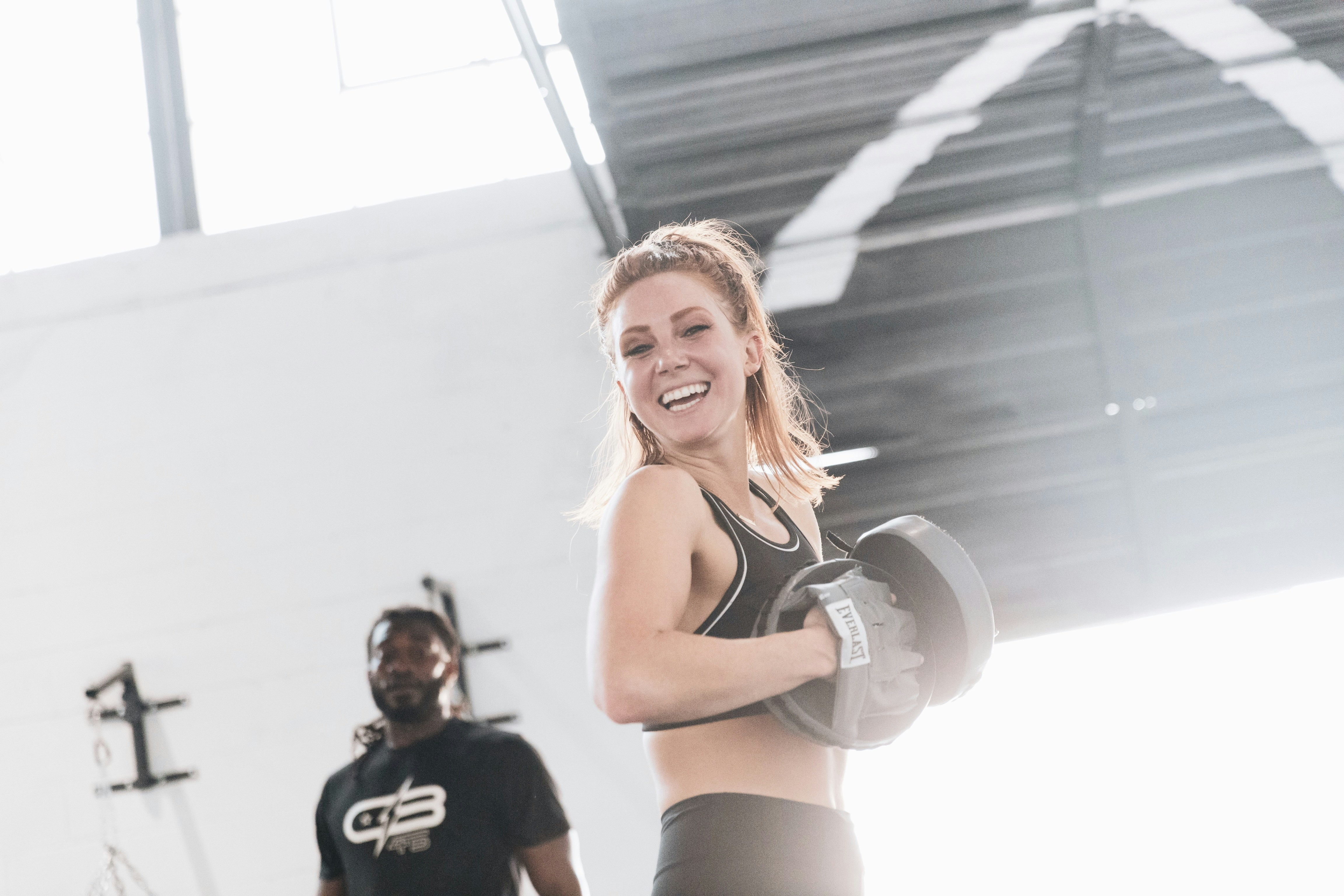 a person smiling and feeling accomplished in a fitness setting - toned body gym workout