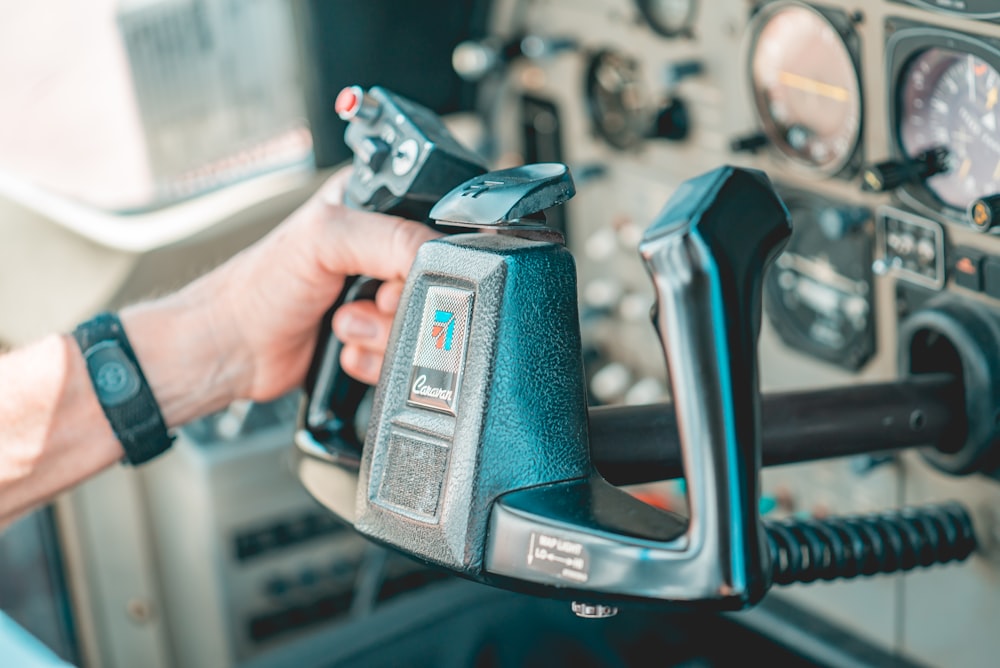 person holding gray and black cordless power tool