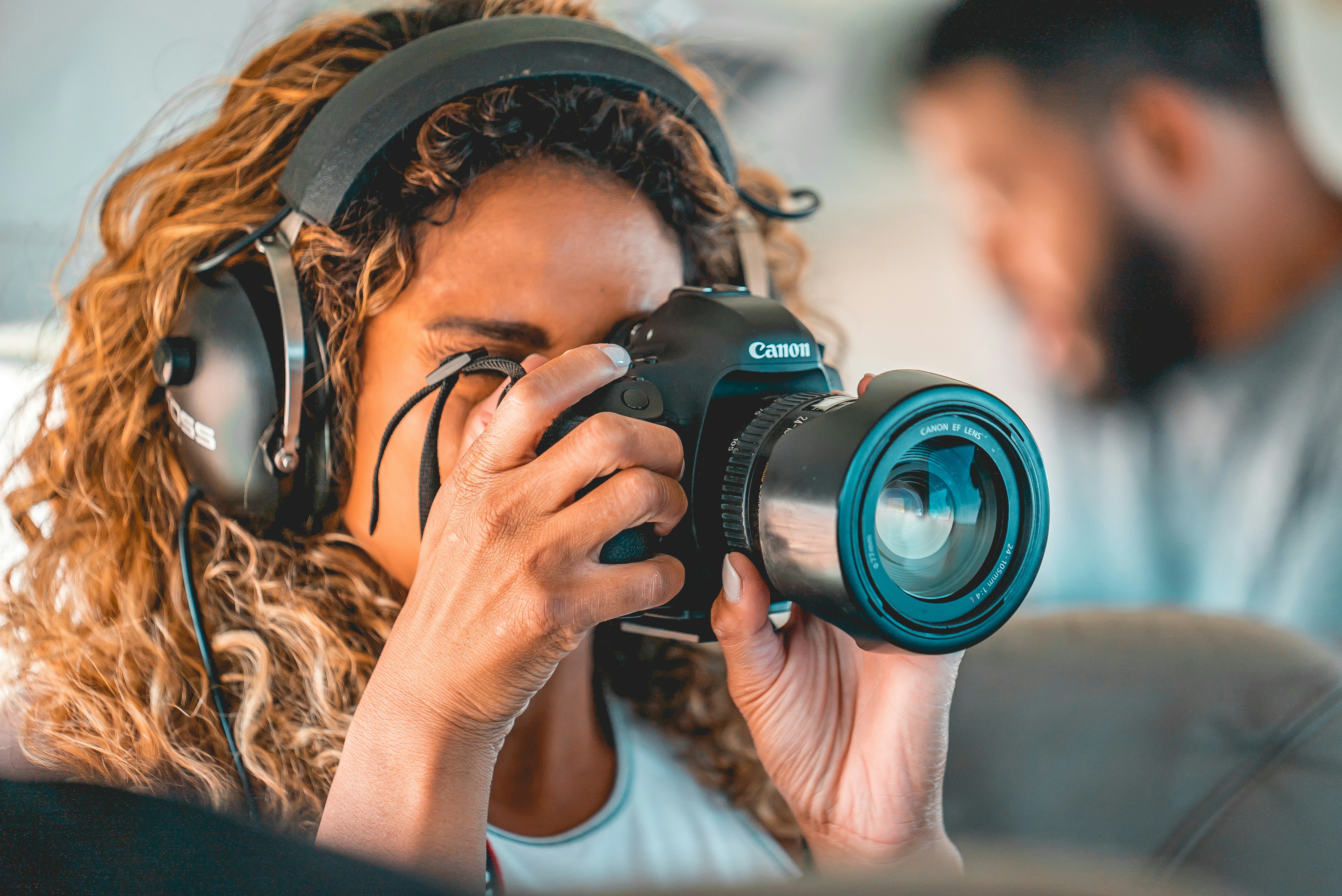 Femme en chemise blanche tenant un appareil photo reflex numérique Nikon noir
