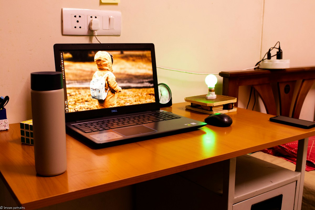 Black laptop on wooden table, ideal for virtual classroom setup and exploring best practices for teaching online.