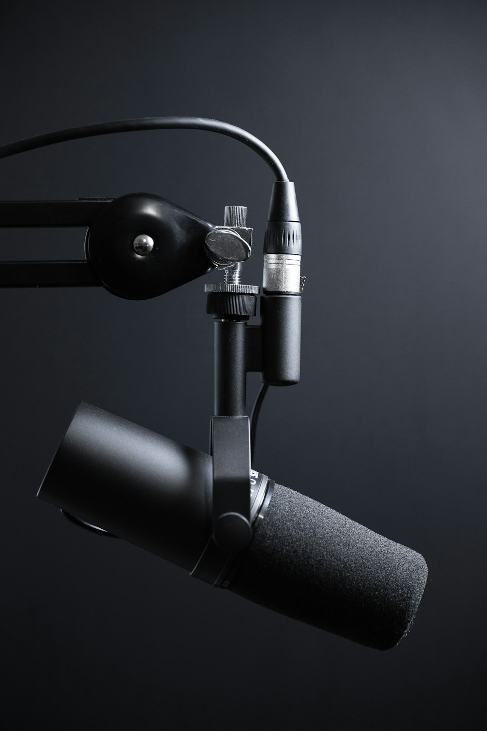 Microfone preto e prateado com suporte