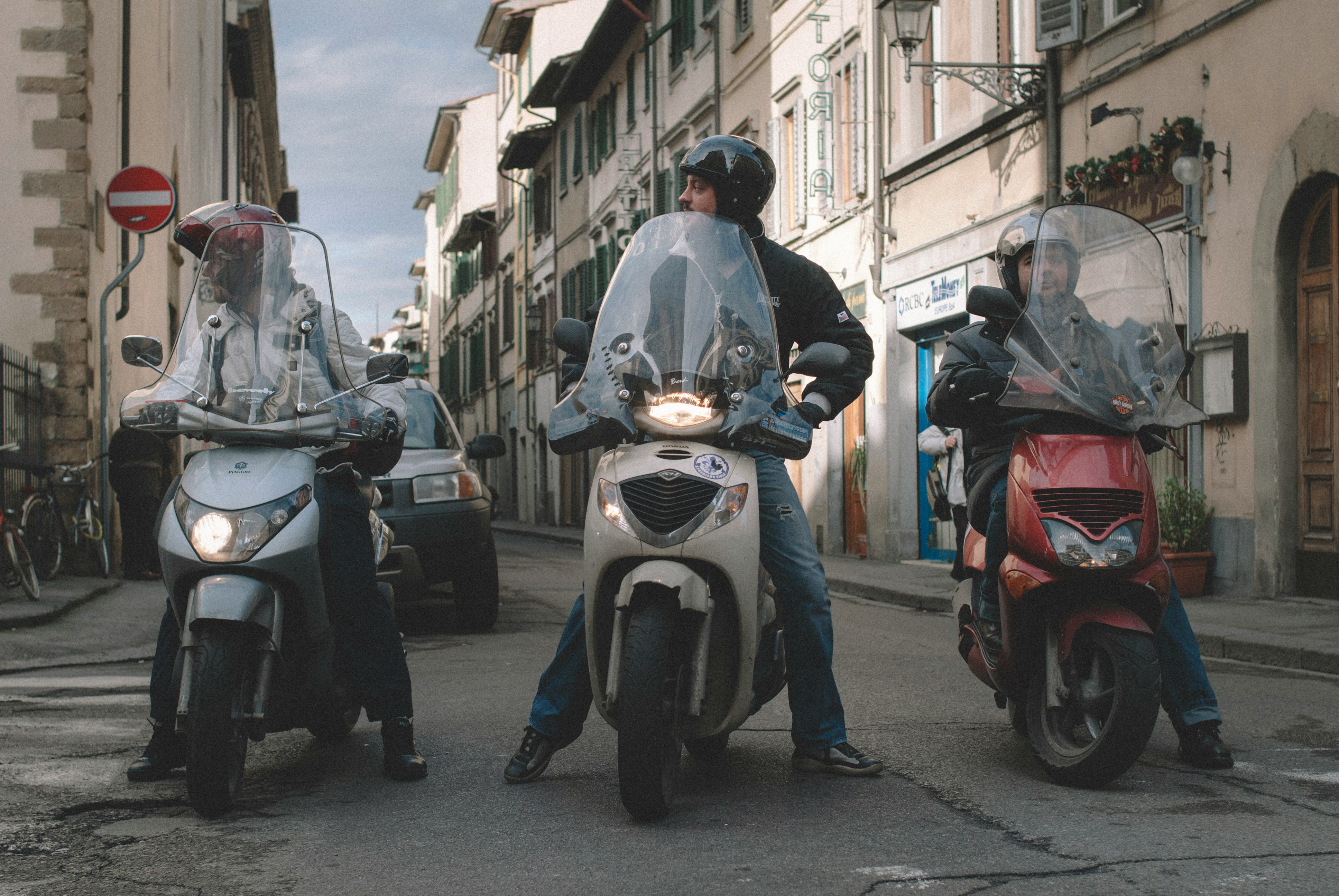 man in blue jacket riding on white motor scooter during daytime