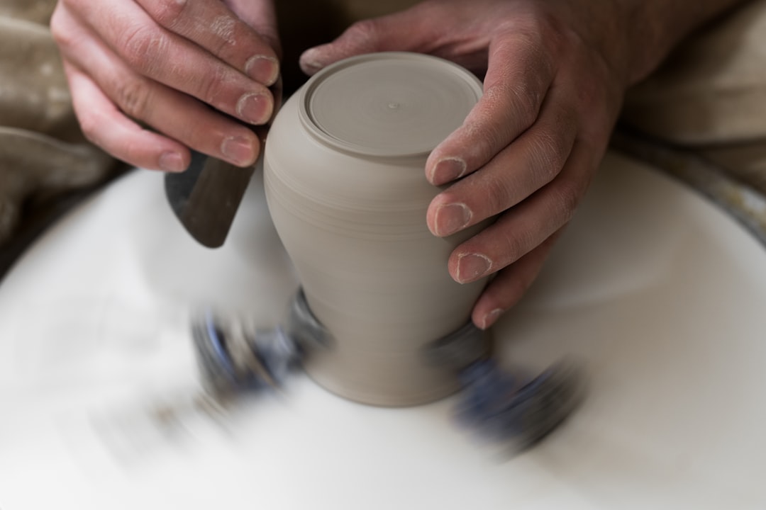 person pouring white liquid on white ceramic cup