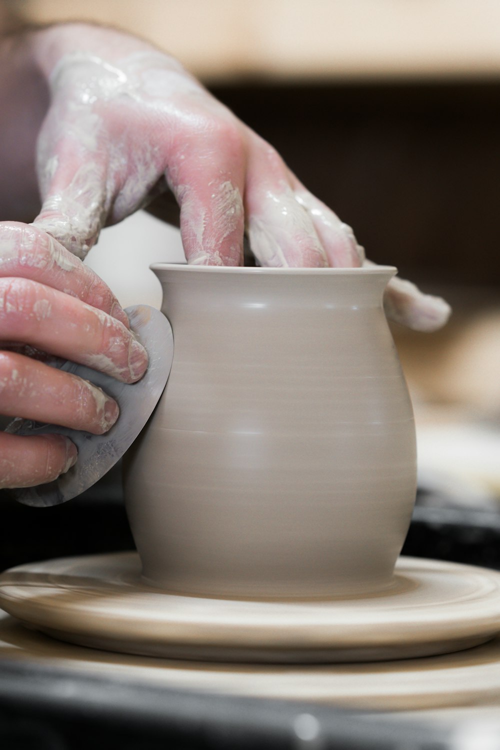 Persona che tiene in mano un vaso di terracotta bianca