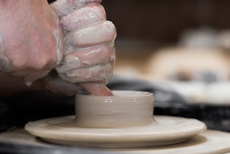 Children learning pottery at a workshop with concentrated expressions.